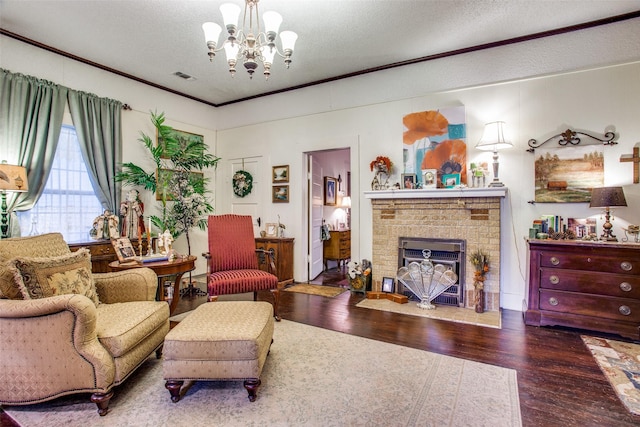 living room featuring a textured ceiling, wood finished floors, visible vents, ornamental molding, and a brick fireplace