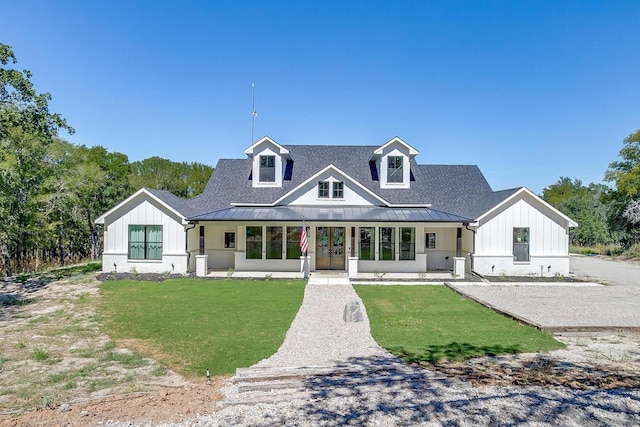 modern farmhouse with a standing seam roof, metal roof, a front lawn, and roof with shingles