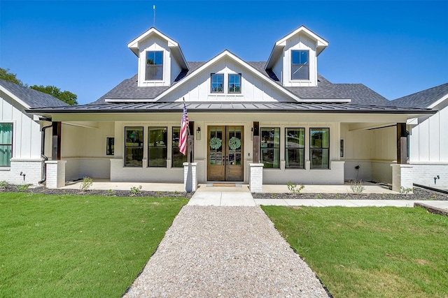 modern farmhouse with french doors, a standing seam roof, a shingled roof, and a front yard