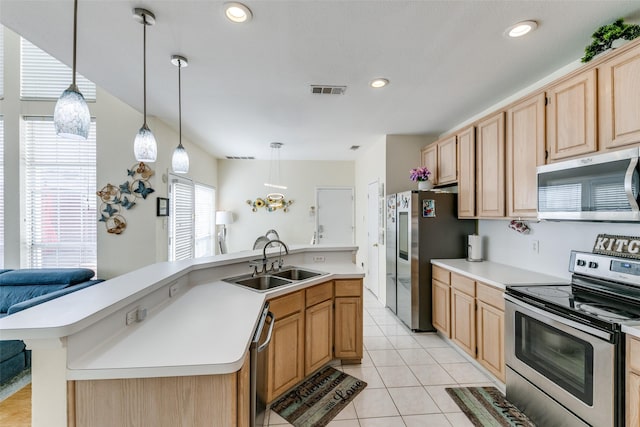 kitchen featuring light tile patterned floors, appliances with stainless steel finishes, light countertops, light brown cabinets, and a sink