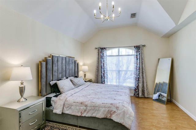 bedroom with a notable chandelier, lofted ceiling, visible vents, light wood-type flooring, and baseboards