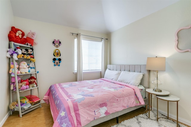 bedroom featuring vaulted ceiling, wood finished floors, and baseboards