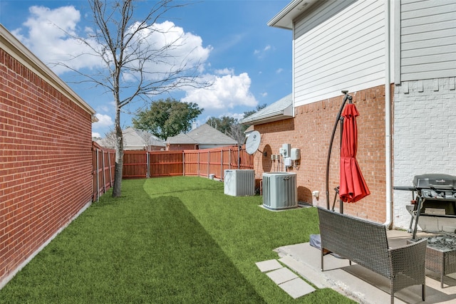 view of yard with central air condition unit and a fenced backyard