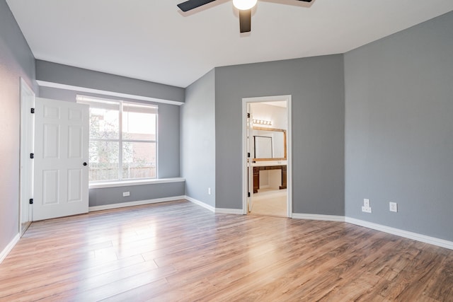 spare room featuring light wood-style floors, baseboards, and ceiling fan