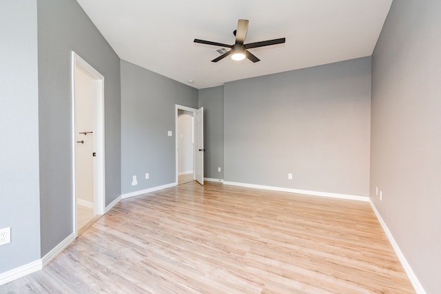 unfurnished room with ceiling fan, light wood-style flooring, and baseboards