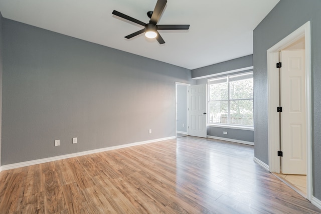 unfurnished bedroom with ceiling fan, baseboards, and wood finished floors