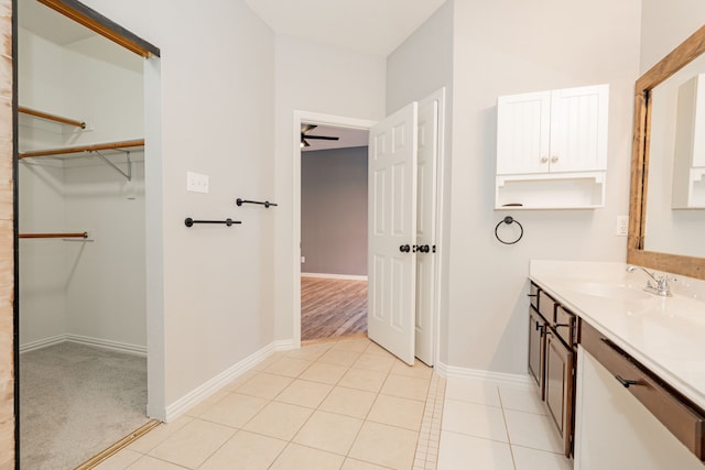 bathroom featuring a spacious closet, baseboards, vanity, and tile patterned flooring