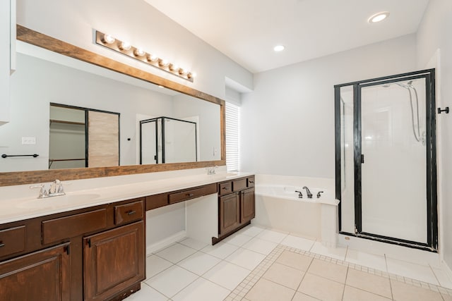 bathroom featuring a stall shower, a garden tub, a sink, and tile patterned floors