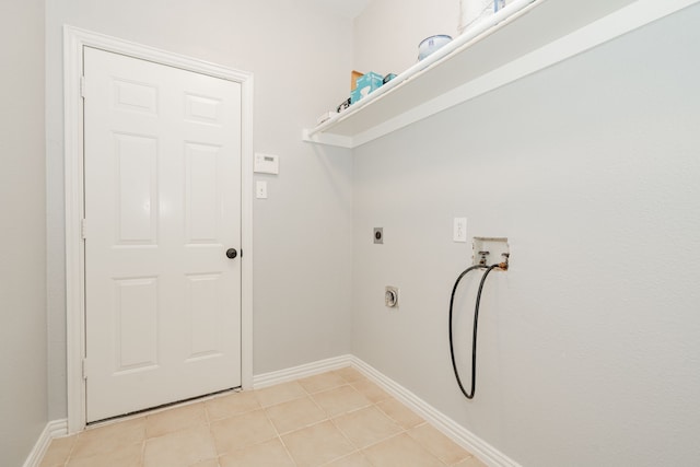 clothes washing area with light tile patterned floors, hookup for a washing machine, laundry area, baseboards, and electric dryer hookup