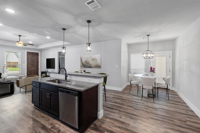 kitchen featuring dark wood-style floors, visible vents, a kitchen island with sink, a sink, and dishwasher