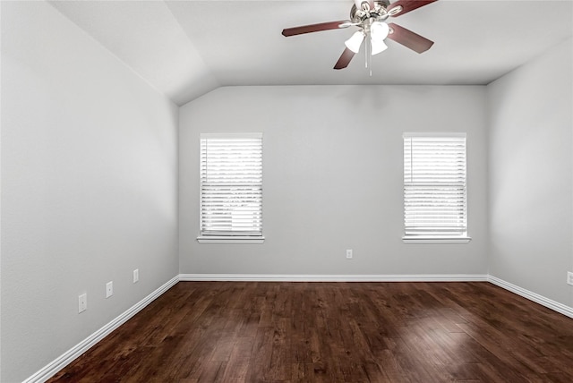 empty room featuring lofted ceiling, ceiling fan, baseboards, and dark wood-style flooring