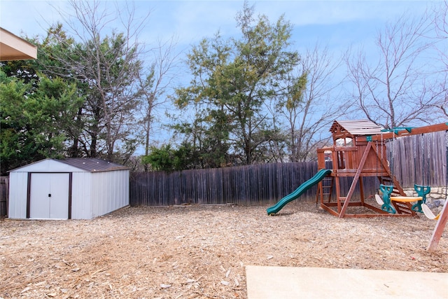 view of yard featuring a playground, an outdoor structure, a fenced backyard, and a shed