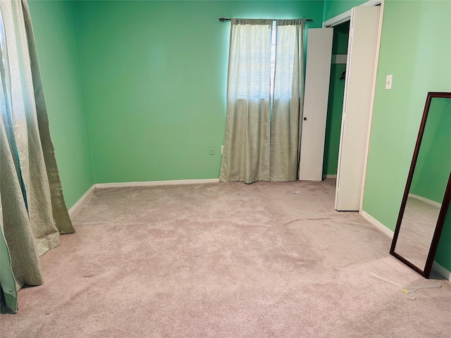 unfurnished bedroom with carpet floors and baseboards