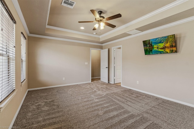 unfurnished bedroom featuring baseboards, visible vents, a tray ceiling, and carpet flooring