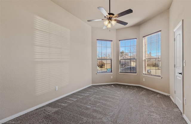 carpeted spare room featuring ceiling fan and baseboards