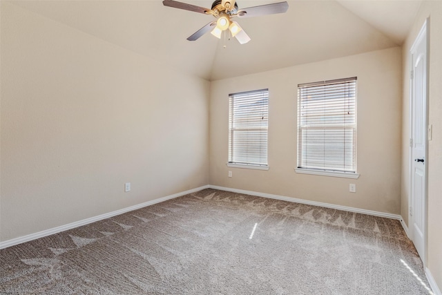 empty room featuring lofted ceiling, ceiling fan, carpet floors, and baseboards