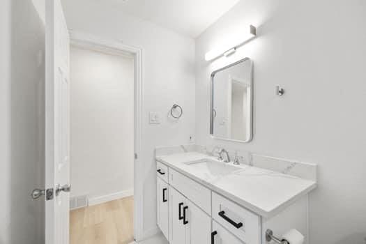 bathroom featuring wood finished floors, vanity, and baseboards