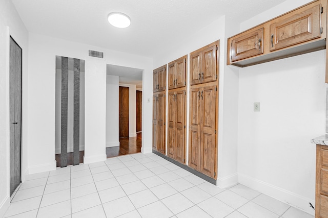 interior space with light tile patterned floors, visible vents, and baseboards