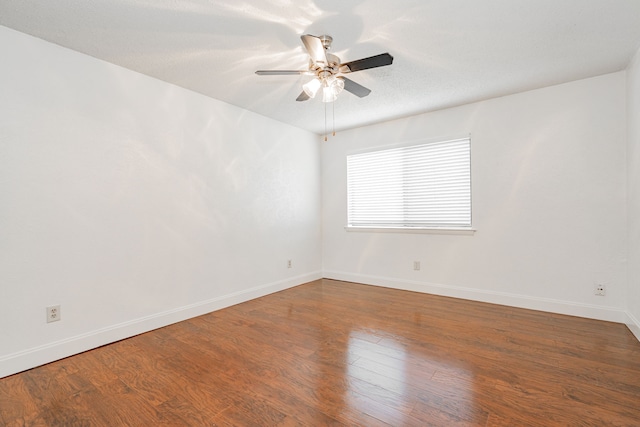 spare room with ceiling fan, a textured ceiling, baseboards, and wood finished floors