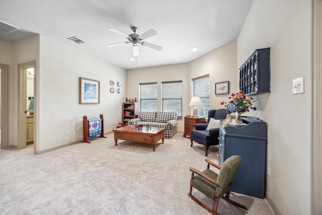 living area featuring light carpet, baseboards, visible vents, and a ceiling fan