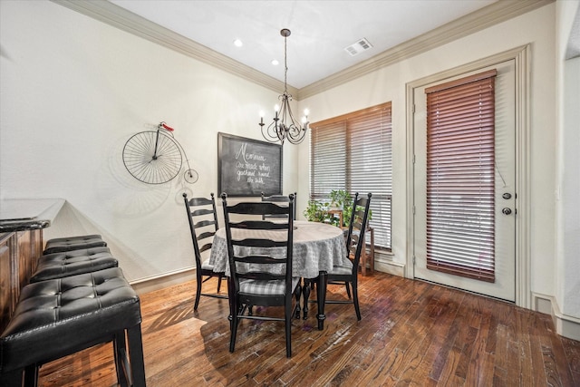 dining space featuring a chandelier, visible vents, crown molding, and hardwood / wood-style flooring