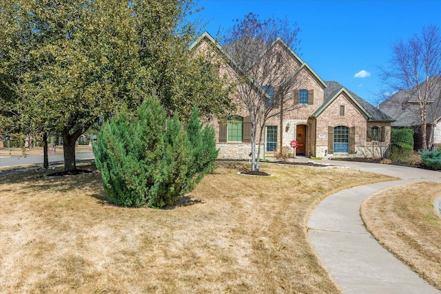 view of front of property featuring a front yard and brick siding