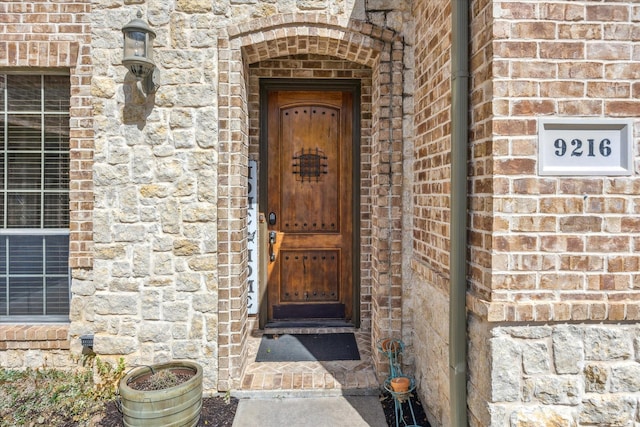 entrance to property featuring brick siding