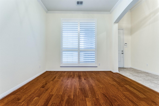 spare room featuring ornamental molding, arched walkways, visible vents, and wood finished floors