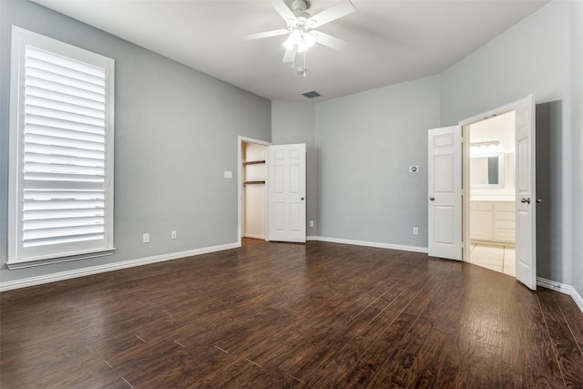 interior space featuring visible vents, ensuite bath, baseboards, and wood finished floors