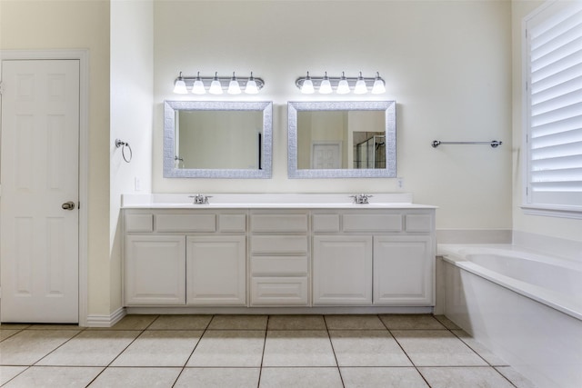 full bath with a garden tub, double vanity, a sink, and tile patterned floors