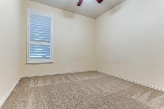 carpeted empty room featuring ceiling fan and baseboards