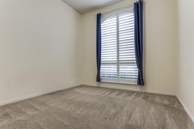 empty room with carpet and baseboards