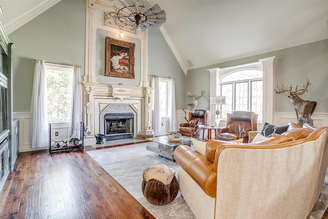 living room featuring a healthy amount of sunlight, hardwood / wood-style flooring, a premium fireplace, and wainscoting