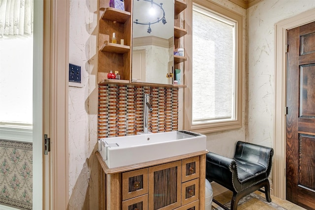 bathroom featuring wallpapered walls and a sink