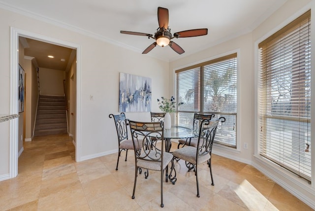 dining space with ornamental molding, ceiling fan, baseboards, and stairs