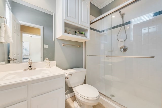 bathroom with a stall shower, vanity, toilet, and crown molding