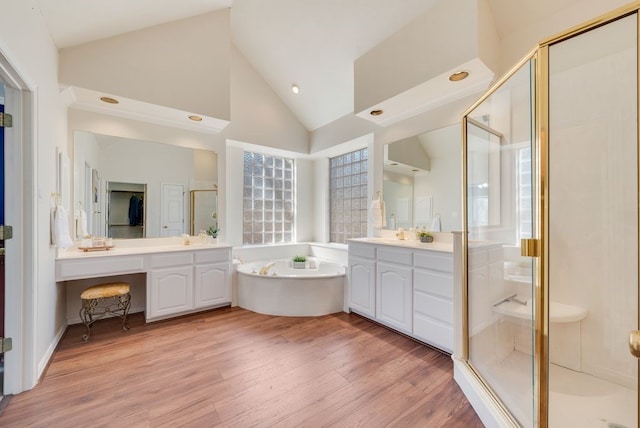 bathroom with vanity, a shower stall, wood finished floors, high vaulted ceiling, and a bath