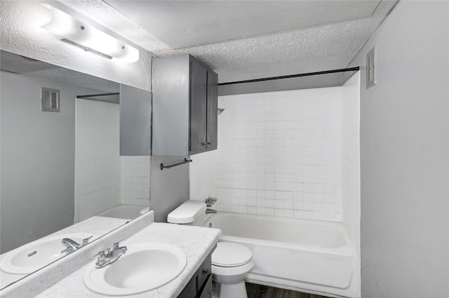 bathroom with a textured ceiling, toilet, vanity, visible vents, and shower / washtub combination