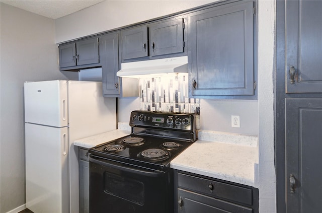 kitchen featuring freestanding refrigerator, under cabinet range hood, and electric range