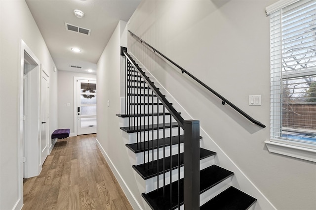 stairway featuring recessed lighting, visible vents, baseboards, and wood finished floors