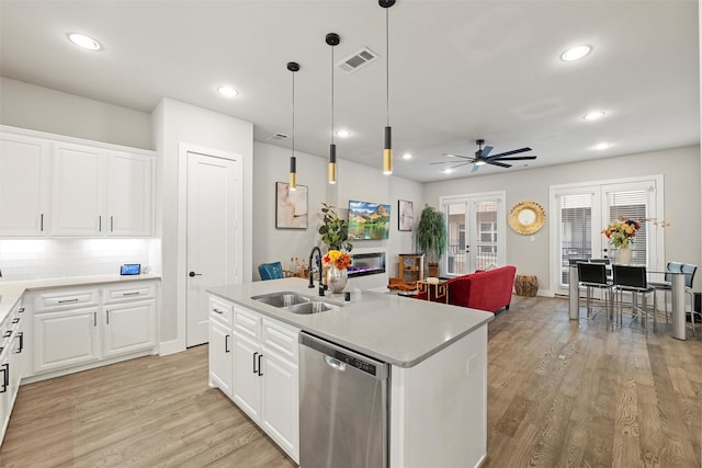 kitchen with french doors, visible vents, light wood-style flooring, a sink, and dishwasher