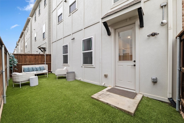 exterior space with stucco siding, a lawn, fence, and an outdoor hangout area