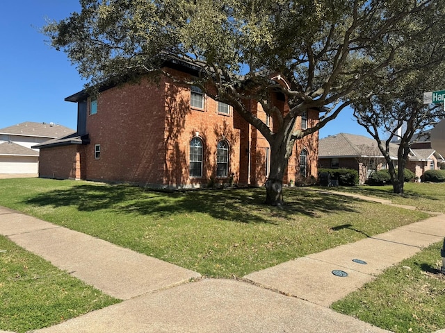 view of front of property with a front yard and brick siding