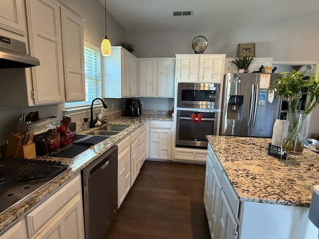 kitchen featuring under cabinet range hood, a sink, visible vents, appliances with stainless steel finishes, and light stone countertops