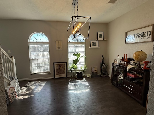 dining space with stairs, dark wood-style flooring, plenty of natural light, and a textured ceiling