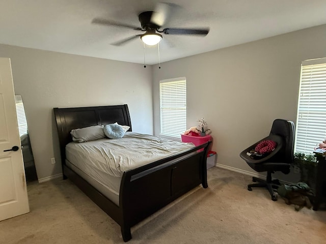 bedroom featuring light colored carpet, ceiling fan, and baseboards