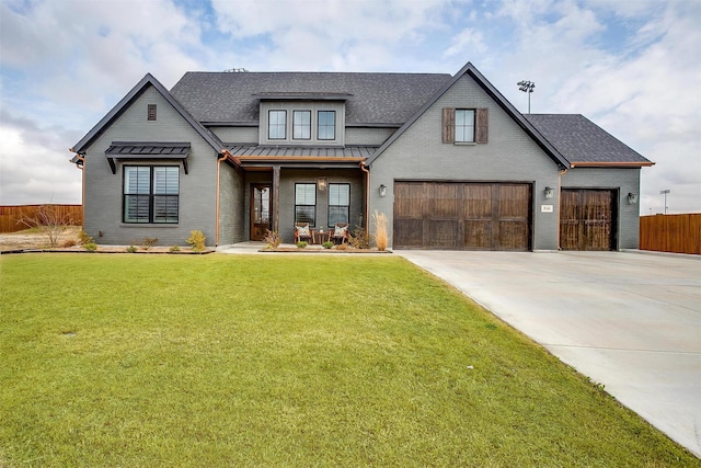 modern inspired farmhouse featuring metal roof, fence, concrete driveway, a standing seam roof, and a front yard