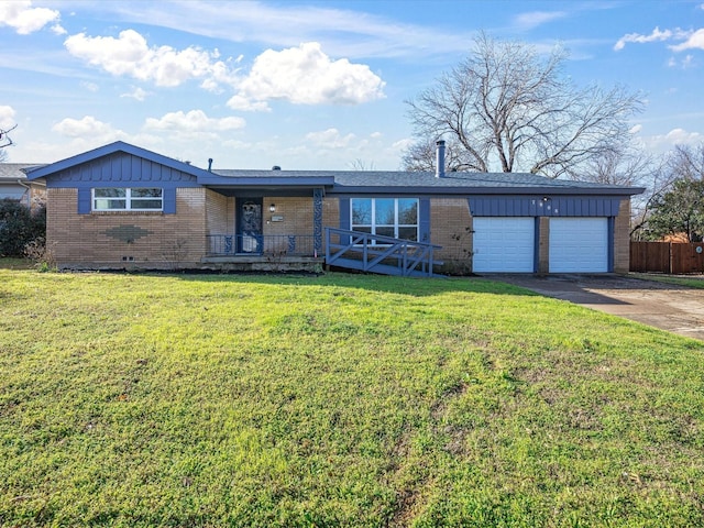 view of front facade featuring a garage, driveway, brick siding, fence, and a front yard