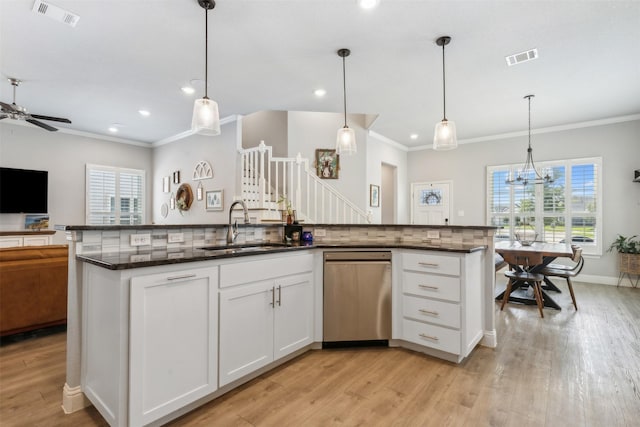 kitchen with a sink, visible vents, open floor plan, stainless steel dishwasher, and dark stone countertops