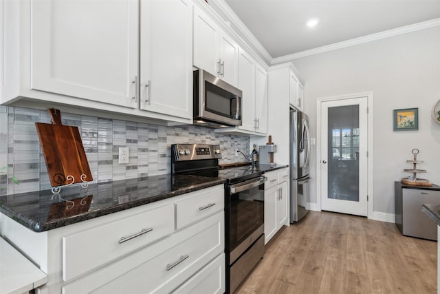 kitchen with light wood finished floors, decorative backsplash, appliances with stainless steel finishes, ornamental molding, and white cabinetry